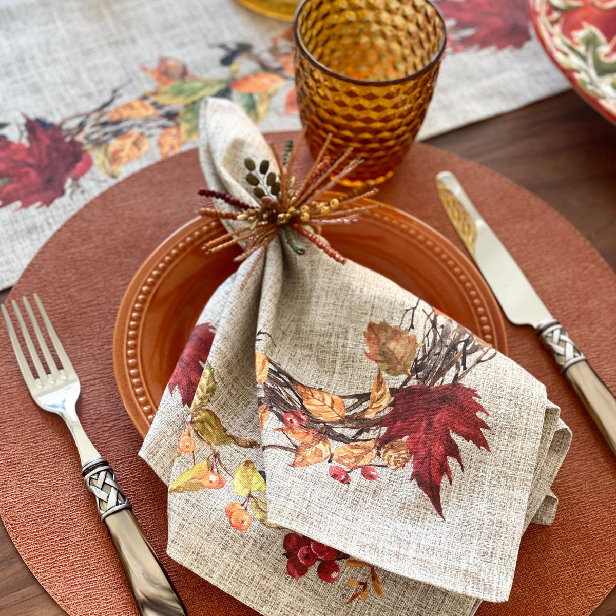 All about Thanksgiving. Cotton napkins with harvest motif print featuring acorns, mixed berries and fall leaves. Combined with Autumn Napkin rings and terracotta placemat.