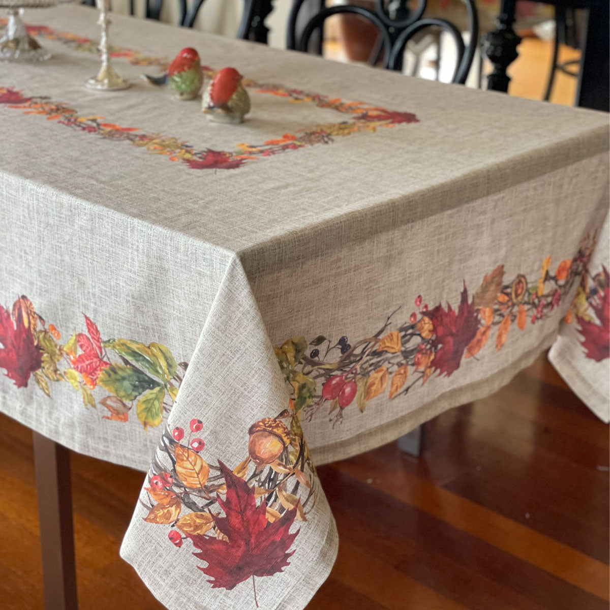 Cotton print tablecloth for Thanksgiving, harvest motif with Fall leaves, acorns and mixed berries on a beige background.