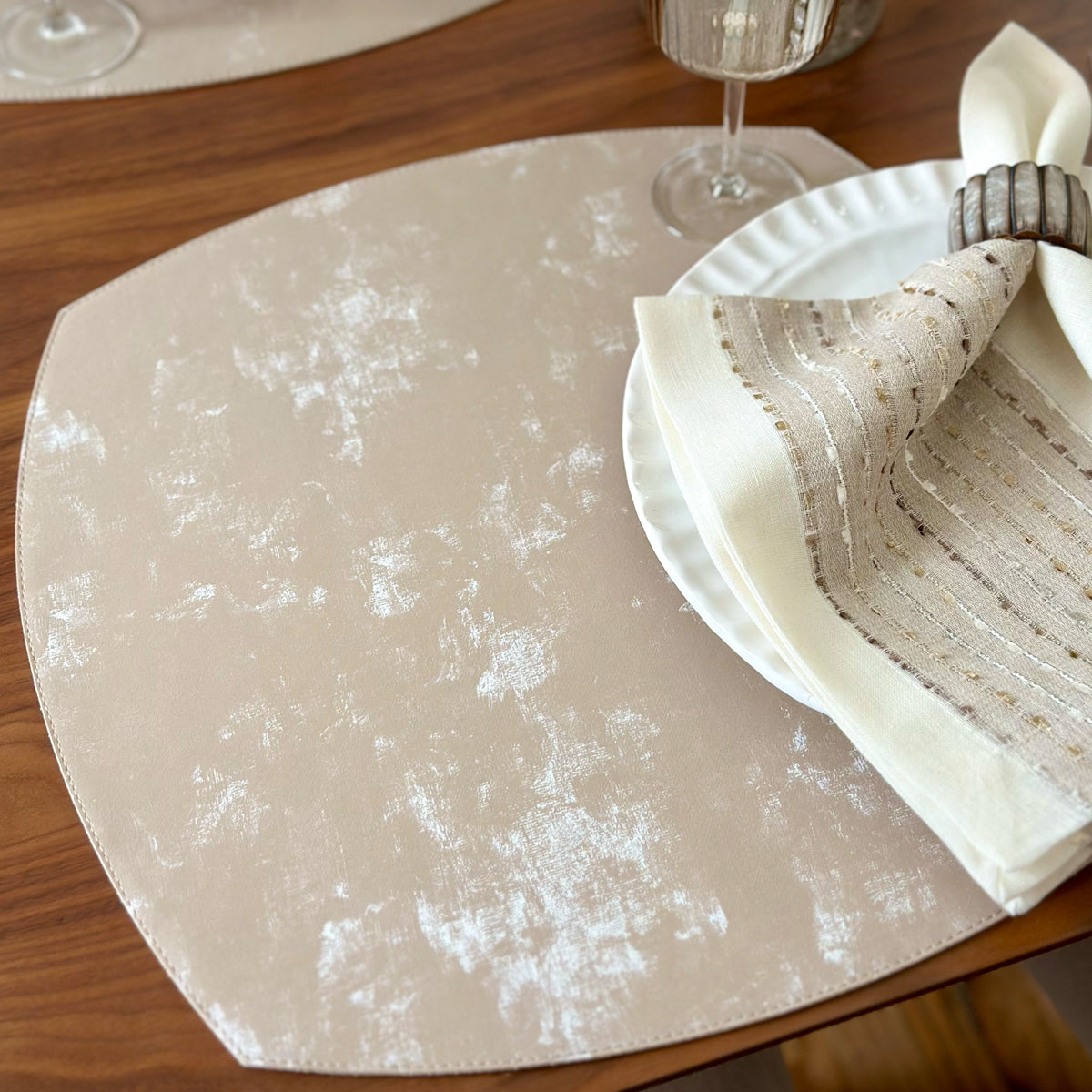 Napkin with gold accents and a pearl like napkin ring to the side of the placemat, showcasing the vinyl placemat shine and texture that looks and feels like velvet.