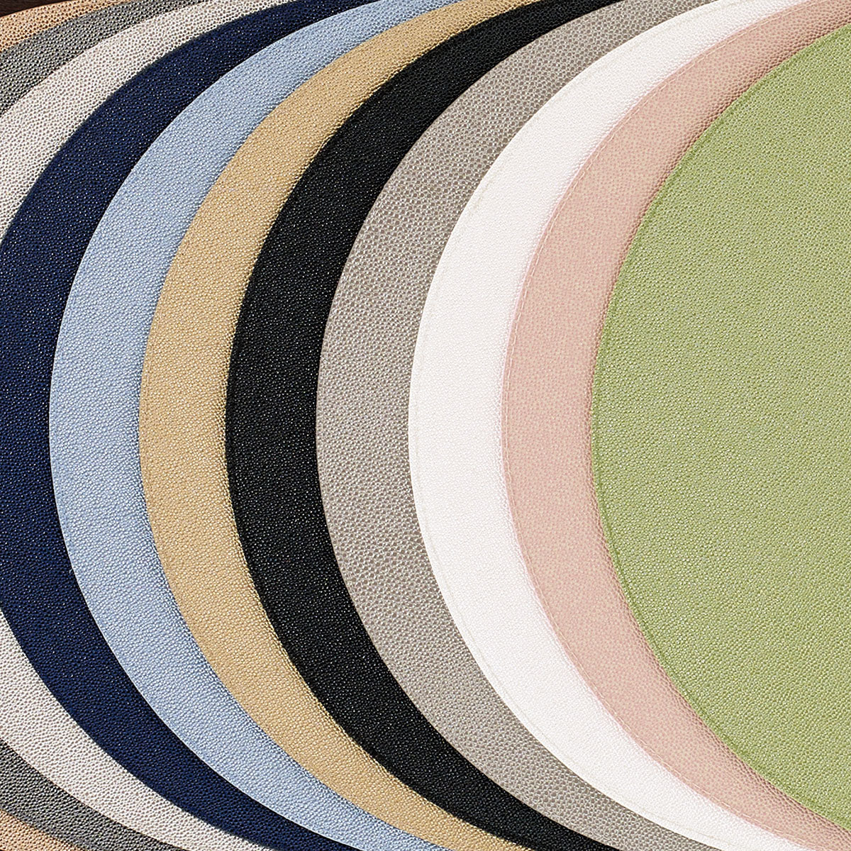 Round vinyl placemats with shagreen finish in a variety of colors, willow, rose, oyster, gray, black, gold, ice blue, navy, pearl.